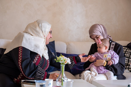 Mother and grandmother are playing with baby wearing beautiful clothes celebrating and enjoying their moments with childrenの写真素材