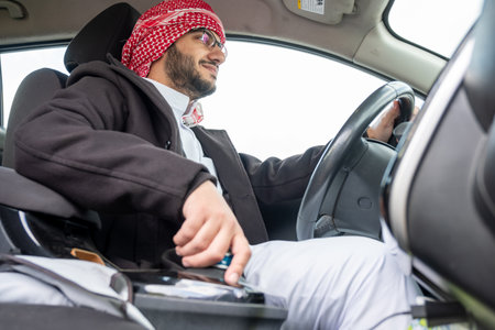 young arab male using phone while driving looking maps or callingの写真素材