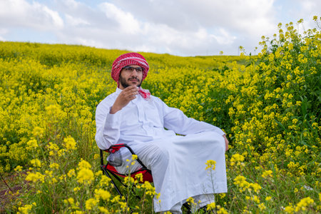 An individual sits in a golden field of flowers at sunrise, arms raised in positivity. The fresh spring air and vibrant sky symbolize health and freedom capturing a moment of harmony and adventureの写真素材