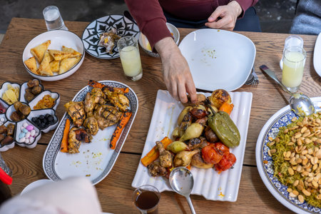 A family gathers around a rectangular table, sharing a heartwarming meal together, with members of various ages adding to the warmth and joy of the occasionの写真素材