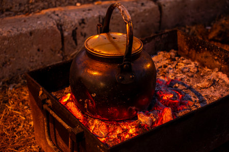 burning coals to boil water during camping and metal stove on picnicの写真素材