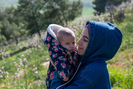 Mother and baby enjoying their time together on a picnic amidst green fields, creating lovely memoriesの写真素材
