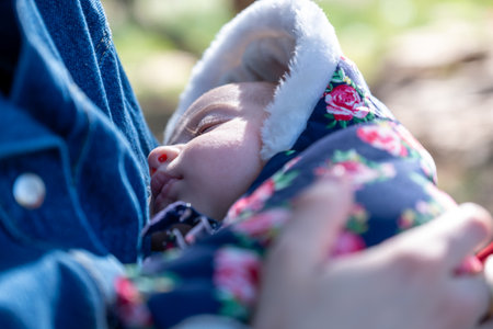 Mother and baby enjoying their time together on a picnic amidst green fields, creating lovely memoriesの写真素材
