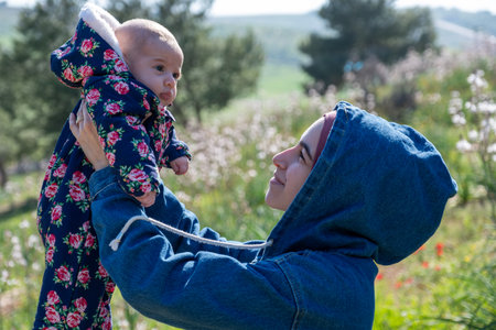 father, mother and baby enjoying their time together on a picnic amidst green fields, creating lovely memoriesの写真素材