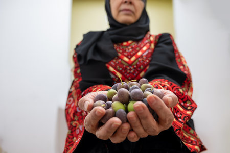 Palestinian female holding heep of olives in her handsの写真素材