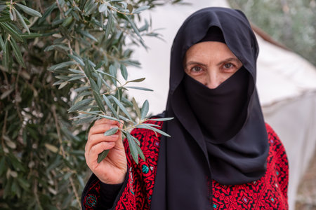 Portrait for woman wearing traditional clothes in refugee camp behinde olive treeの写真素材