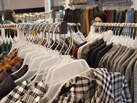 Clothing on hanger at the modern shop boutique with females selecting  at the backgroundの写真素材