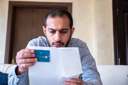 male holding bank card while feeling stressed due to financial issueの写真素材