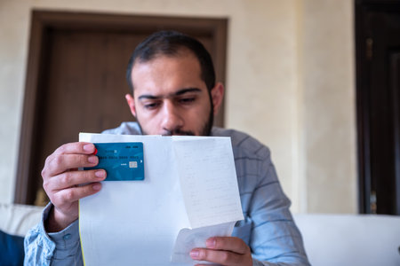 male holding bank card while feeling stressed due to financial issueの写真素材