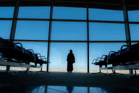 Silhouette airport waiting seats and window with blue skyの写真素材