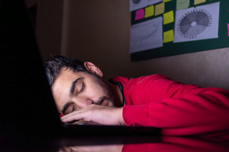 male sleeping on his desk during workingの写真素材