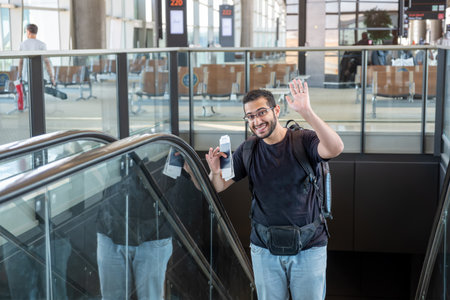 Cheerful male holding his passport after long journey feeling excited to be back to home