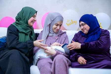Females are celebrating a new baby and holding it indoors, with gifts and balloons around.