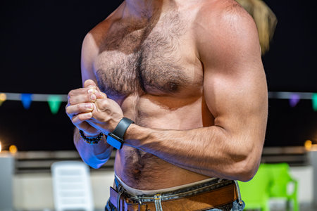 young bearded male showing off muscles in front of pool during his vacation with confident face and poseの写真素材