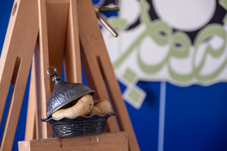 Eid sweets with drawing canvas canvas holder on blue background with arabic calligraphyの写真素材