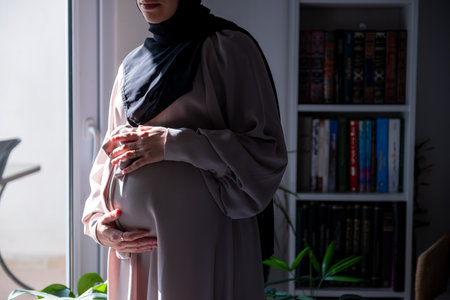 Pregnant muslim woman with home libraryの写真素材
