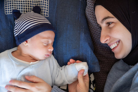 Arabic Muslim parents share a tender moment with their newborn daughter, radiating love and joy in their home.の写真素材