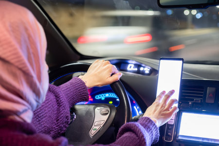 arabic muslim woman driving car at night wearing winter clothes ,hijab and seat belt driving in...