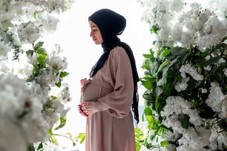 Female touches her tummy feeling her new baby in living room with copy space