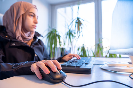 Muslim female working in office using computer with white background, represent power of arabian womanの写真素材