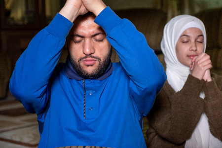 muslim couples praying together asking allah for mercy and forgiveness ,wearing casual clothes in...
