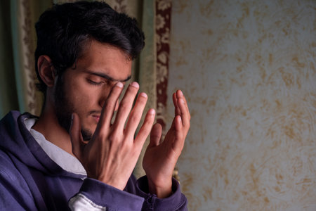 muslim male rising his hands to pray for allah and asking for forgiveness and helpの写真素材