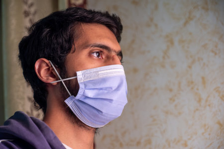 Male wearing mask and praying to protect him from diseases and help him being wellの写真素材