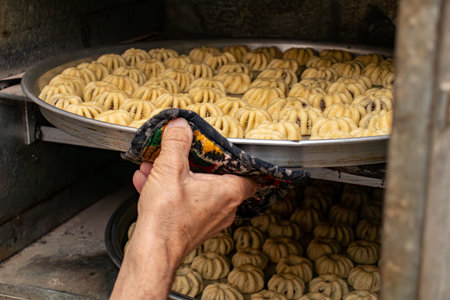 Man hands baking eid kahk in arabian oven