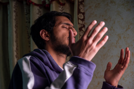 muslim male rising his hands to pray and asking for forgiveness and helpの写真素材