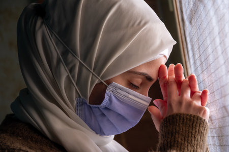 Muslim woman wearing mask and praying for allah  to protect her from diseasesの写真素材