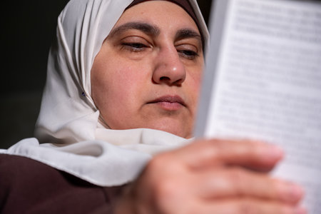 Muslim female wearing hijab reading bookの写真素材