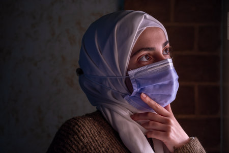 Muslim woman wearing mask and praying for allah  to protect her from diseasesの写真素材