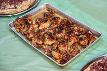 grilled Chicken tray ready to be eaten with people hands and musakhan breadの写真素材