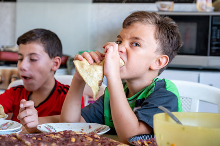 Portrait for kids eating in kitchen togetherの写真素材