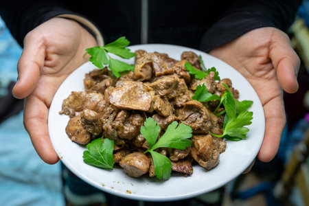 Hands holding dish for gizzard, livers and heartsの写真素材