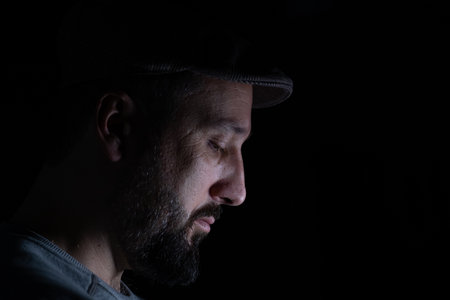 Man wearing glasses on black background with face expressionsの写真素材