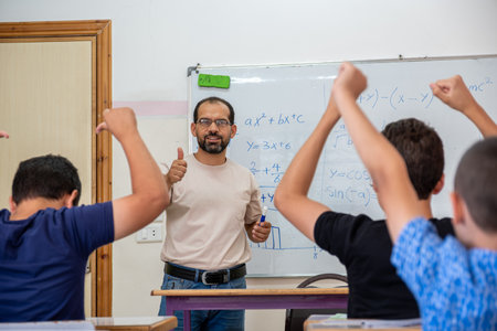 Children's in school so excited with their teacher and raising their hands to answer the teacher...