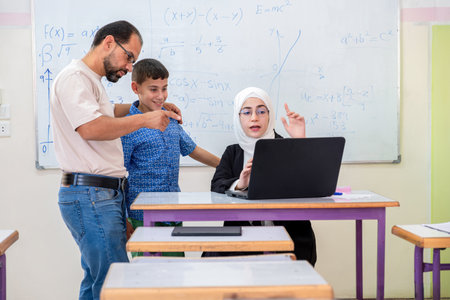 Father having conversation with the teacher in school about his son's academic progress.