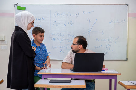 Mother having conversation with the teacher in school about here son academic Progress