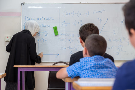 Children's in school so excited with their teacher and raising their hands to answer the teacher...