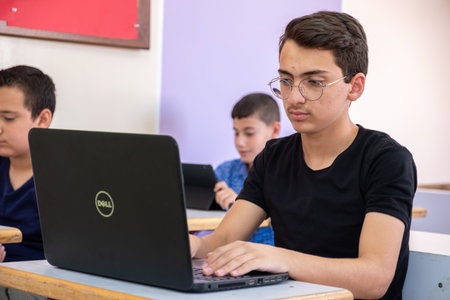arabic teenager using laptop while studying in the school