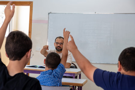 Students raising their hands to answer the teacher question