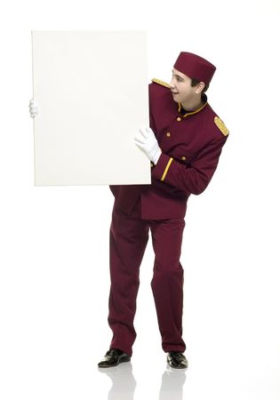 Usher with red uniform holds up a white panel.の写真素材