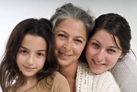 mother and  two daughters embracing and looking at camera