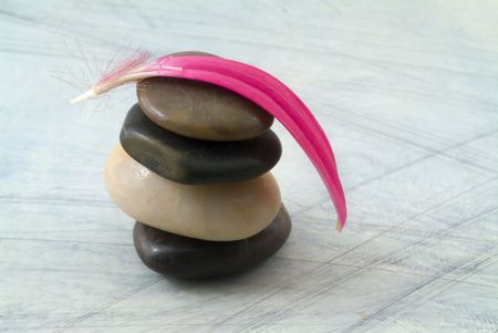 balancing stones and pink gerber petal on grungy bluish backgroundの写真素材