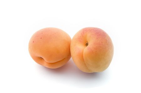 two  apricots isolated on whiteの写真素材