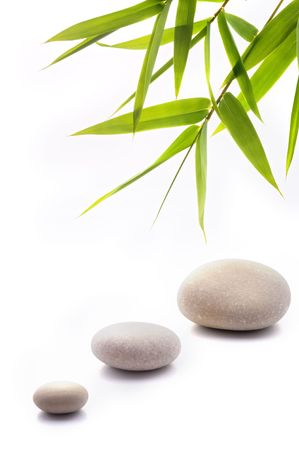 bamboo leavs and three stones isolated on whiteの写真素材