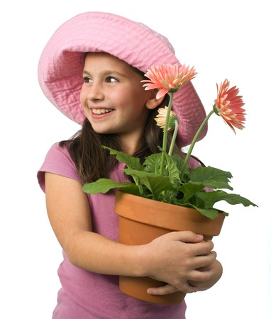 young girl with a pink hat and pink daisies in a flowerpotの写真素材