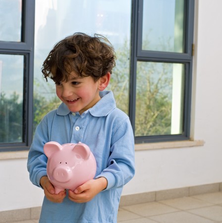 young boy holding a piggy bankの写真素材
