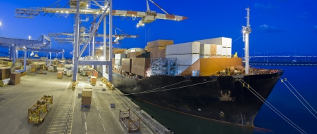 cargo ship at dock by night panoramaの写真素材